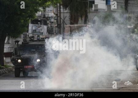 Naplouse, Palestine. 13th mai 2023. De la fumée s'élève après l'explosion d'une bombe faite maison devant un véhicule militaire israélien dans le camp de réfugiés de Balata, lors d'un raid dans le camp, à l'est de Naplouse, en Cisjordanie occupée. Les forces de l'armée israélienne ont attaqué le camp de réfugiés de Balata, entouré et détruit une maison contenant des personnes recherchées. Deux civils palestiniens ont été tués pendant le raid, et les personnes recherchées ont fui, l'opération militaire a échoué. Crédit : SOPA Images Limited/Alamy Live News Banque D'Images