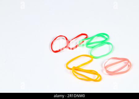 Pile de couleurs colorées, arc-en-ciel, bandes élastiques multicolores sur fond blanc. Banque D'Images