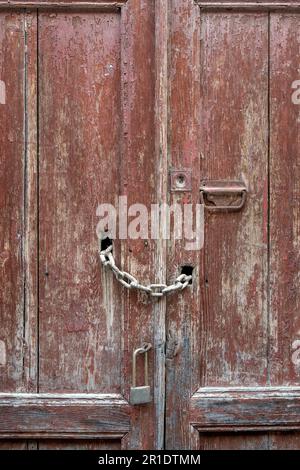 Ancienne porte en bois rugueuse avec boulons et cadenas. Détails du fer et du bois. Banque D'Images