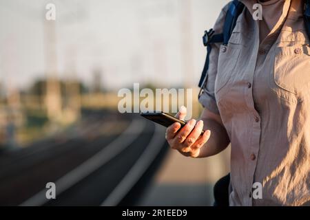 Femme achetant un billet de chemin de fer en ligne pour s'entraîner avec une application mobile sur son smartphone Banque D'Images