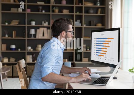 Un jeune travailleur indépendant sérieux analyse le schéma d'affaires Banque D'Images