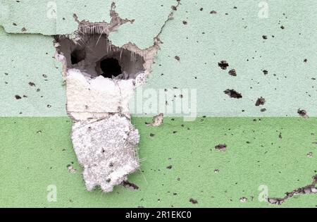 Trous des balles et de l'obus dans le mur sur la ligne avant. Cicatrices de guerre. Mur en béton d'un bâtiment résidentiel avec des nids-de-poule et des trous de gunf Banque D'Images