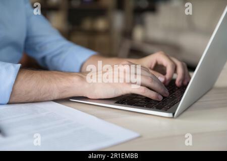 Jeune homme d'affaires caucasien travaillant à l'ordinateur portable, dactylographiant sur le clavier Banque D'Images