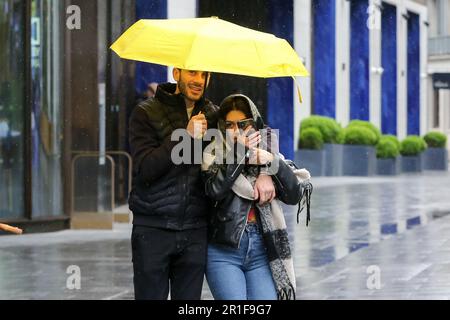 Londres, Royaume-Uni. 12th mai 2023. Un couple est placé sous un parapluie par temps humide dans le centre de Londres. Le bureau met prévoit que les températures à Londres atteindront 20 degrés Celsius samedi après la pluie, le tonnerre et l'éclairage cette semaine. Crédit : SOPA Images Limited/Alamy Live News Banque D'Images