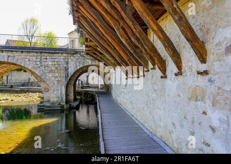 Promenade dans le passage voûté sous le pont en pierre enjambant la rivière Loing dans la ville médiévale de Moret-sur-Loing en Seine et Marne, France Banque D'Images