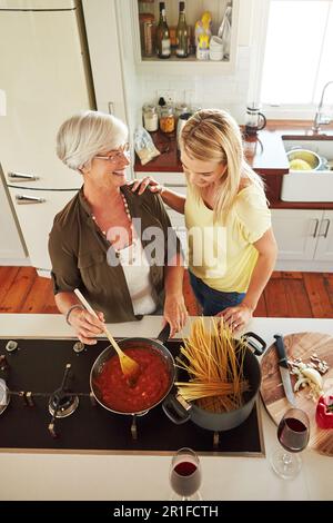 Enseignement, femme ou mère heureuse cuisinant de la nourriture pour une alimentation saine avec l'amour dans la maison familiale. Drôle, au-dessus ou adulte l'apprentissage ou l'aide d'enfant Banque D'Images