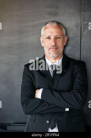 Homme d'affaires, portrait et heureux avec un sourire sur le visage avec les bras croisés en studio. Un entrepreneur principal ou un cadre dirigeant sur un mur gris avec Banque D'Images