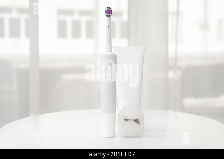 Brosse à dents électrique avec pâte sur la table dans la chambre Banque D'Images