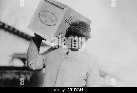 Photo d'archives: Homme afro-américain portant un étui de whisky 'four Roses' sur son épaule, éventuellement confisqué par les États-Unis Bureau du revenu interne ca. 1921 Banque D'Images
