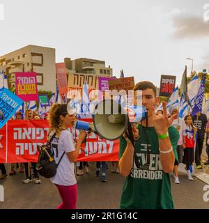 Haïfa, Israël - 13 mai 2023 : les gens marchent avec des drapeaux et divers signes. 19th semaines de manifestations anti-gouvernementales à Haïfa, Israël Banque D'Images