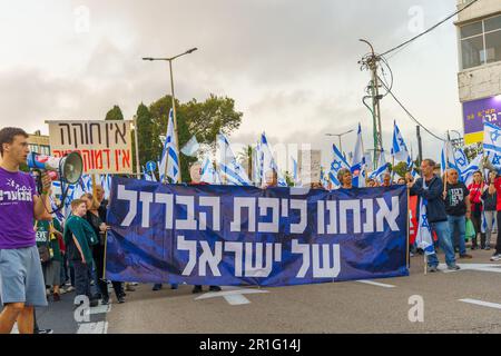 Haïfa, Israël - 13 mai 2023 : les gens marchent avec des drapeaux et divers signes. 19th semaines de manifestations anti-gouvernementales à Haïfa, Israël Banque D'Images