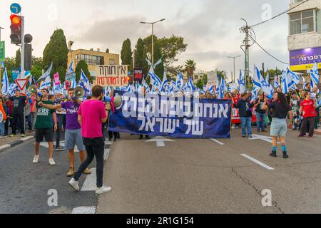Haïfa, Israël - 13 mai 2023 : les gens marchent avec des drapeaux et divers signes. 19th semaines de manifestations anti-gouvernementales à Haïfa, Israël Banque D'Images