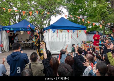 Tokyo, Japon. 14th mai 2023. Les gens regardent des tours de masque de l'Opéra du Sichuan lors d'un festival de nourriture du Sichuan qui s'est tenu au parc central de Nakano, Tokyo, Japon, on 14 mai 2023. Le festival de la gastronomie du Sichuan s'est tenu ici de 13 mai à 14 mai. Credit: Zhang Xiaoyu/Xinhua/Alay Live News Banque D'Images