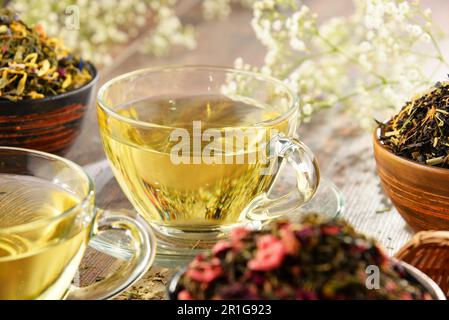 La composition avec tasse de thé et des bols de feuilles de thé Banque D'Images