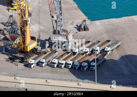 Vue de dessus des tracteurs-remorques garés au port près des énormes grues jaunes. Banque D'Images