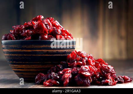 La composition avec bol de canneberges séchées sur table en bois Banque D'Images