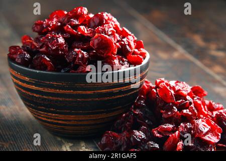 La composition avec bol de canneberges séchées sur table en bois Banque D'Images