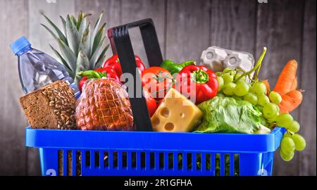 Panier en plastique avec un assortiment de produits d'épicerie Banque D'Images