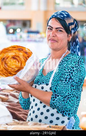 SAMARKAND, OUZBÉKISTAN - 10 MAI 2019 : femme vendant du pain à Siab Bazar dans le centre de Samarkand, Ouzbékistan Banque D'Images