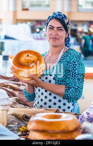 SAMARKAND, OUZBÉKISTAN - 10 MAI 2019 : femme vendant du pain à Siab Bazar dans le centre de Samarkand, Ouzbékistan Banque D'Images