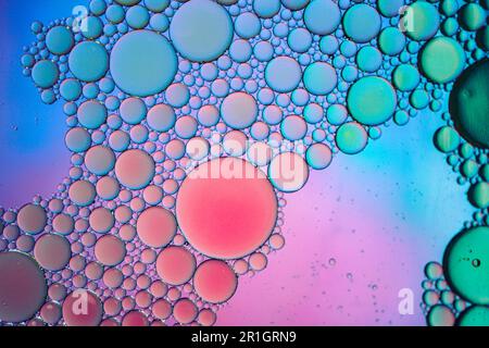 cercles d'huile multicolores sur l'eau, fond coloré Banque D'Images