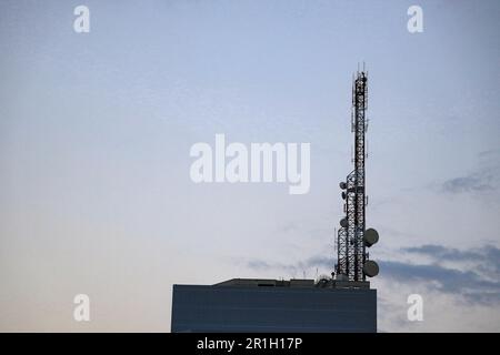 Antenne émettrice et radio Tour sur le dessus du bâtiment, structure en acier, cadre pour bâtiment métallique moderne avec beau ciel. Banque D'Images