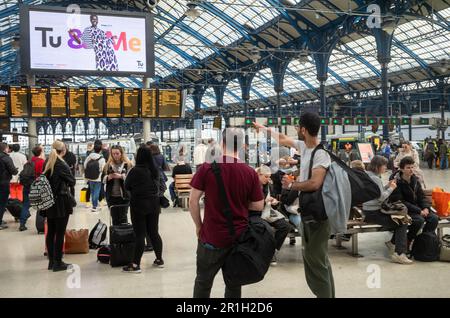 Passagers attendant sur le hall de la gare de Brighton à East Sussex, Royaume-Uni, alors qu'un seul homme pointe à la carte électronique des départs. Le victorien Banque D'Images