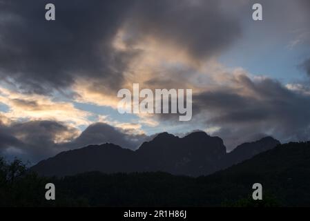 un tramonto con nuvole colorate di arancione nelle dolomiti Banque D'Images