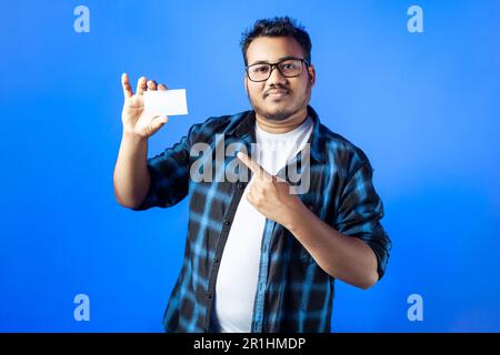 Homme de race blanche d'Inde montrant une carte de visite blanche vide, isolée sur un fond de couleur unique Banque D'Images