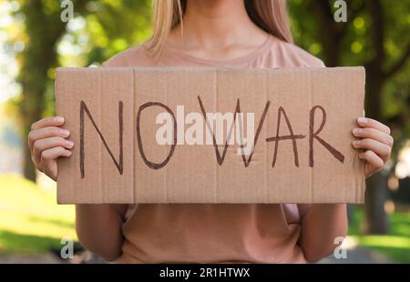 Femme tenant une affiche avec des mots No War dans le parc, gros plan Banque D'Images