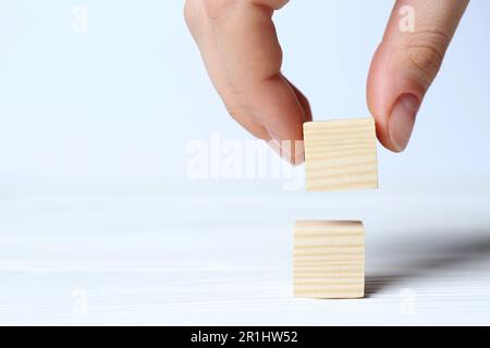 Femme organisant des cubes sur fond blanc, gros plan avec de l'espace pour le texte. Concept d'idée Banque D'Images
