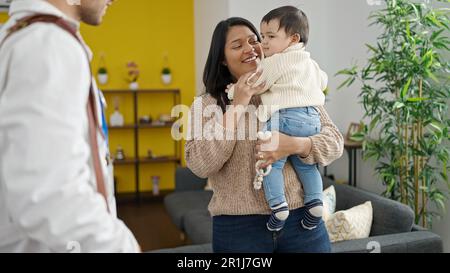 Couple et fils souriant confiant ayant une consultation médicale à la clinique Banque D'Images