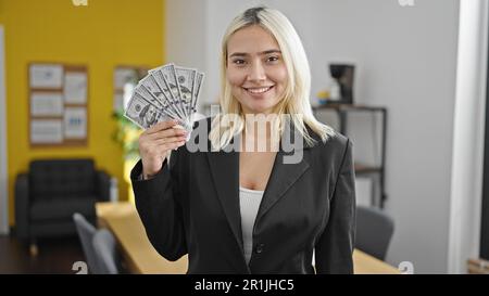 Jeune belle femme hispanique travailleur d'affaires tenant des dollars au bureau Banque D'Images