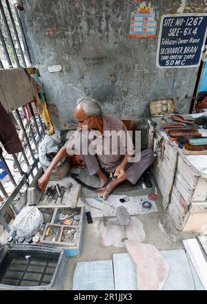 Un cordonnier indien dans un atelier de réparation de ceinture de rue à Delhi, en Inde Banque D'Images