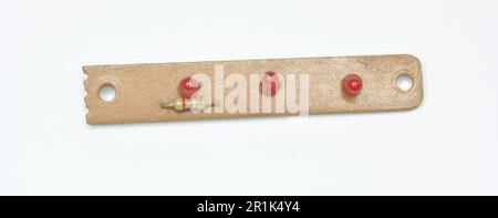Barre en plastique avec petites lampes rouges et résistance sur fond blanc Banque D'Images