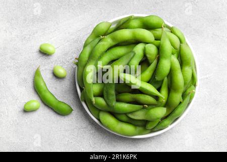 Haricots edamame verts dans les gousses sur la table gris clair, à plat Banque D'Images