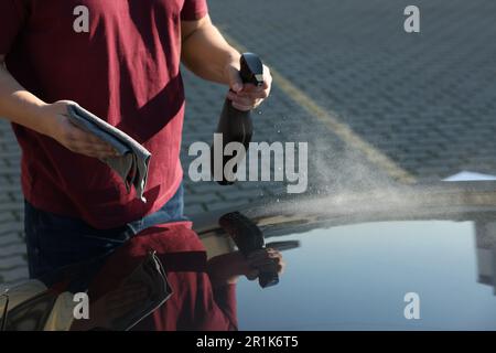 Homme nettoyant le capot de voiture à l'extérieur, vue rapprochée Banque D'Images