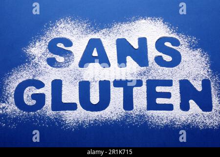 Expression sans gluten écrit en français avec de la farine sur fond bleu, vue de dessus Banque D'Images