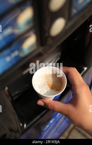 Femme prenant une tasse de papier avec café du distributeur automatique, vue au-dessus Banque D'Images