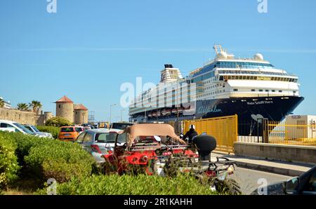 Un grand bateau de croisière bleu a amarré au port de Rhodes. Les palmiers poussent à proximité, les voitures sont garées et les bâtiments médiévaux sont visibles. Rhodes 16.05.22 Banque D'Images