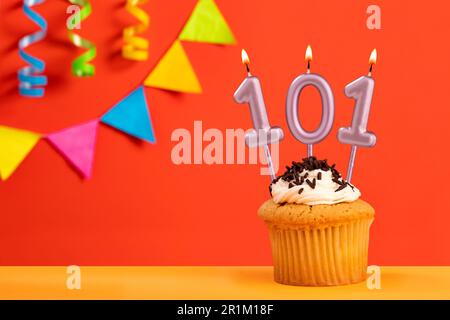 Bougie numéro 101 - gâteau d'anniversaire sur fond orange avec banderole Banque D'Images