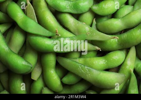 Beaucoup de haricots verts edamame dans les gousses comme arrière-plan, gros plan Banque D'Images