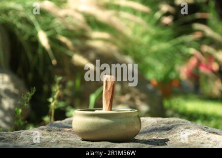 Palo santo Stick dans le support sur la pierre à l'extérieur Banque D'Images