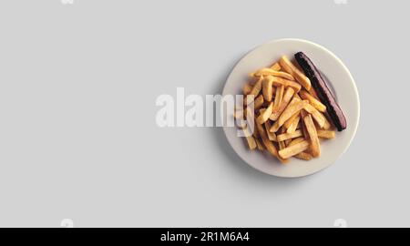 Frites dans une assiette sur fond gris. vue rapprochée. Banque D'Images