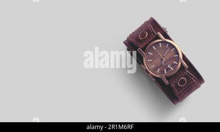 Vue rapprochée de la montre-bracelet homme en cuir marron sur fond gris. Banque D'Images