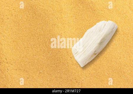 Indicateur de direction en bois sur le sable. Petit morceau de bois pour logo. Espace de copie ajouté. Banque D'Images