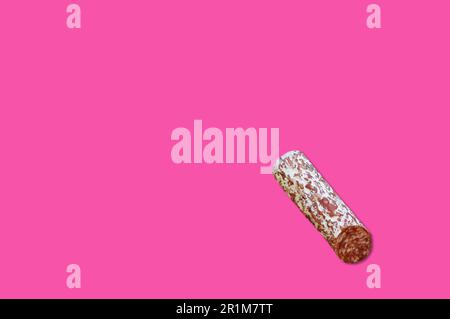 Morceau de viande de bacon fumé isolé sur fond rose. Banque D'Images