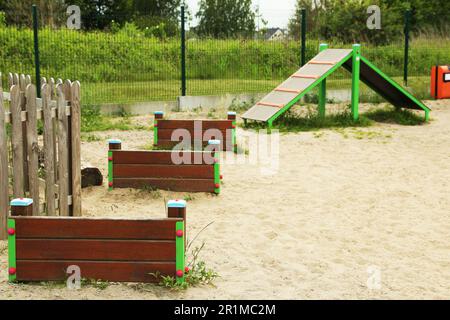 Un véhicule en bois surmonte et monte la colline sur une aire d'entraînement des animaux en plein air Banque D'Images