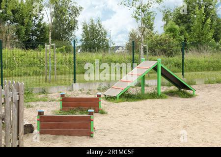 Un véhicule en bois surmonte et monte la colline sur une aire d'entraînement des animaux en plein air Banque D'Images