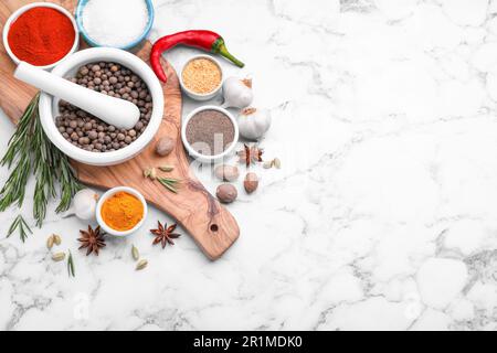 Composition de la pose plate avec mortier et différentes épices sur table en marbre blanc, espace pour le texte Banque D'Images